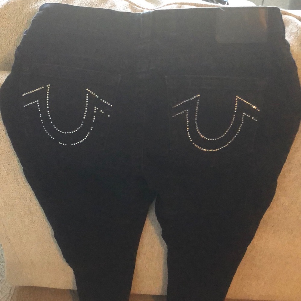 Black True Religion jeans with rim stone pocket emblem some rim stone missing.
